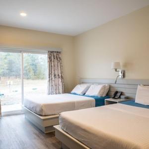 a bedroom with two beds and a window at Leelas Villa Inn Flesherton in Flesherton