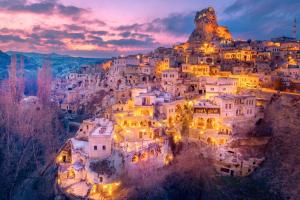 a village on top of a mountain at night at Cappadocia Splendid Cave Hotel in Ortahisar