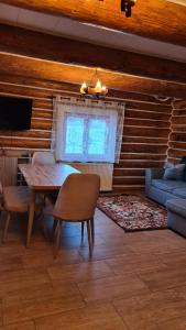- une salle à manger avec une table et un canapé dans l'établissement Cabana Păstrăvului, à Izvoarele Sucevei