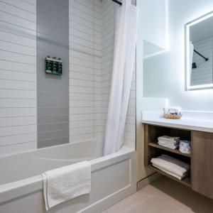 a white bathroom with a tub and a sink at Leelas Villa Inn Flesherton in Flesherton