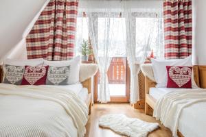 dwa łóżka w pokoju z oknem w obiekcie Domek w Górach - Przy Potoku w Zakopanem