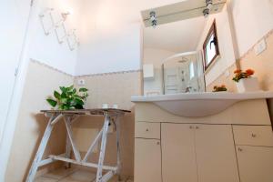 y baño con lavabo y espejo. en Casa Papavero, en San Michele Salentino