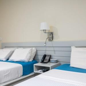 Dormitorio con 2 camas y mesita de noche con teléfono en Leelas Villa Inn Flesherton, en Flesherton