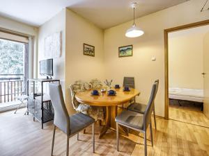 a dining room with a wooden table and chairs at VisitZakopane - Nosal Apartment in Zakopane