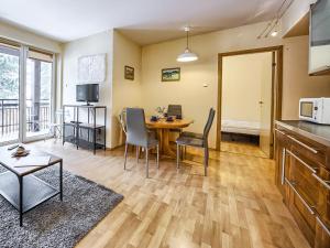 a kitchen and living room with a table and chairs at VisitZakopane - Nosal Apartment in Zakopane