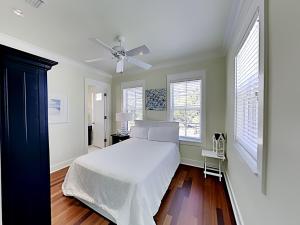 a bedroom with a white bed and a ceiling fan at Watercolor Whimsea in Seagrove Beach +47 photos