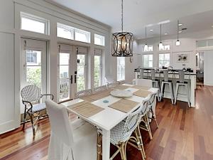 a dining room with a white table and chairs at Watercolor Whimsea in Seagrove Beach
