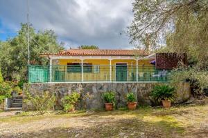 a yellow house with a balcony on a stone wall at Olive Tree Villa in Ieromónachos