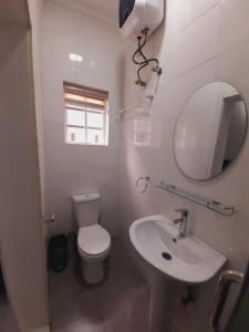 bagno con servizi igienici, lavandino e specchio di The Private Apartments: 2-Bedroom & 3-Bedroom a Port Harcourt