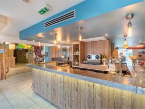 a large kitchen with a large counter top at ibis Styles Marennes d'Oléron in Marennes
