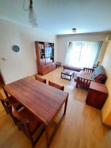 sala de estar con mesa de madera y sofá en Torre Jacarandá de Buenos Aires en Buenos Aires