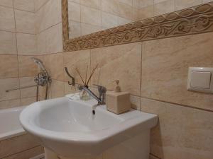 Un baño con un lavabo blanco y un espejo. en Квартира Кравчука 11Б, автостанція, en Teremno