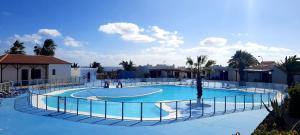 a large swimming pool with a fence around it at Sun beach Caleta 24 in Caleta De Fuste
