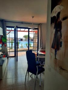 een kamer met een stoel en uitzicht op een zwembad bij Sun beach Caleta 24 in Caleta De Fuste