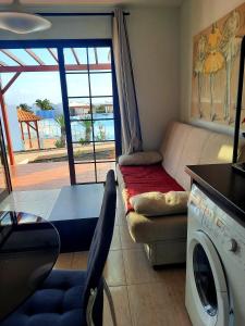a living room with a couch and a washing machine at Sun beach Caleta 24 in Caleta De Fuste