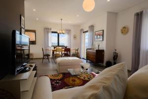 uma sala de estar com um sofá e uma sala de jantar em Laje da Bica Agroturismo na Covilhã
