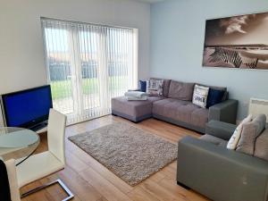 ein Wohnzimmer mit einem Sofa und einem Tisch in der Unterkunft Coastal apartment with beach on your doorstep! in Llanelli