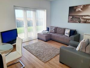 a living room with a couch and a table at Coastal apartment with beach on your doorstep! in Llanelli