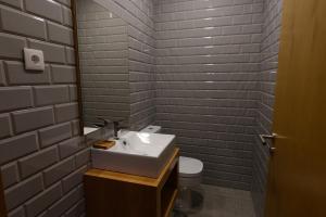 um banheiro com pia e vaso sanitário em Laje da Bica Agroturismo na Covilhã mais 37 fotografias