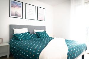 1 dormitorio con 1 cama con sábanas azules y blancas en La Source Positive en Aix-les-Bains