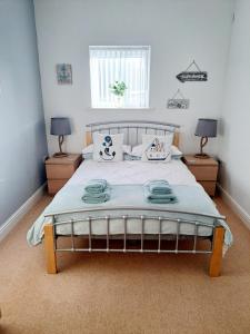 a bedroom with a large bed with two night stands at Coastal apartment with beach on your doorstep! in Llanelli