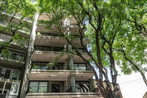 un edificio de apartamentos con árboles delante de él en Lovely studio in Alto Palermo 4A en Buenos Aires