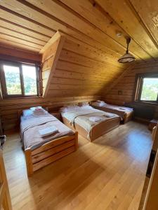 a room with three beds in a log cabin at Góralska Chata & Spa in Muszyna