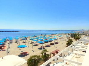a beach with umbrellas and chairs and the ocean at Villa Demì in Lido di Pomposa