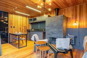 een keuken met een tafel en stoelen en een open haard bij Refúgio de Altitude in Urupema