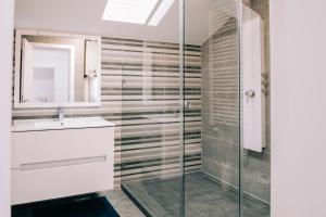uma casa de banho com um lavatório e uma cabina de duche em vidro. em Tulip Guest House I. em Palić