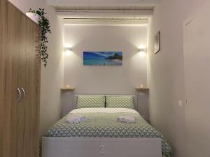 a small bedroom with a bed with two towels on it at Zagara Holiday House Palermo Cattedrale in Palermo