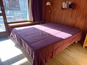 ein Schlafzimmer mit einem lila Bett und einem Fenster in der Unterkunft Appartement Tignes, 2 pièces, 5 personnes - FR-1-449-159 in Tignes