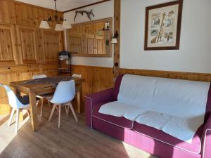 ein Wohnzimmer mit einem lila Sofa und einem Tisch in der Unterkunft Appartement Tignes, 2 pièces, 5 personnes - FR-1-449-159 in Tignes