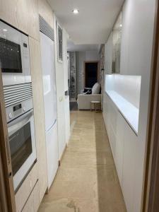 pasillo de una cocina con fogones y nevera en Acogedor apartamento con acabados primera calidad, en Zaragoza