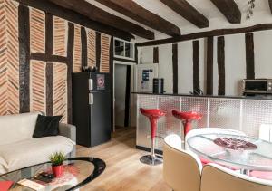 a living room with a table and a refrigerator at "L'Appart" Vieux Tours - Charme - Place Plumereau - Arrivée Autonome in Tours