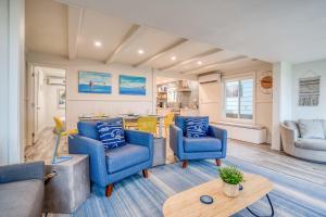 a living room with blue chairs and a table at The Weather Gauge in Rockaway Beach