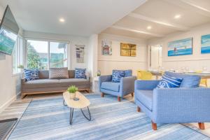 a living room with blue couches and a table at The Weather Gauge in Rockaway Beach