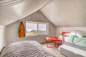 a bedroom with a bed and a window and a surfboard at The Weather Gauge in Rockaway Beach