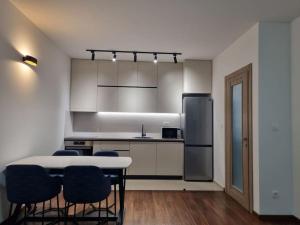 a kitchen with a table and chairs and a refrigerator at Master Quart modern apt. 27 in Podgorica