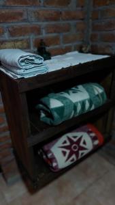 a wooden shelf with towels on it next to a brick wall at Elst House in Mendoza