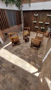 a patio with three wooden benches and a fence at Elst House in Mendoza