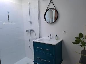 a bathroom with a blue cabinet and a mirror at Le Grenier des Moineaux in Odeillo-Via
