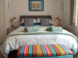 a bedroom with a large bed with a colorful ottoman on it at Scarborough Rose Apartment in Scarborough