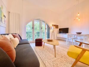 uma sala de estar com um sofá e uma mesa em CasaViva-Stylish Trilo with AC-shared pool-parking em Gênova