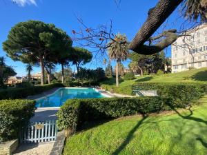 basen w ogrodzie z drzewami i budynek w obiekcie CasaViva-Stylish Trilo with AC-shared pool-parking w Genui