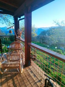 a rocking chair on a porch with a view at Room in Casa Castiglia a Woodhouse with Beautiful View close Madonie Park in Castelbuono