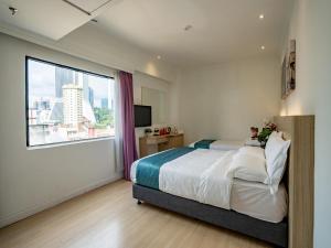 a bedroom with a bed and a large window at Floresta Hotel Chinatown in Kuala Lumpur +100 photos