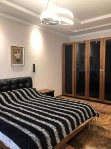 - une chambre avec un lit rayé noir et blanc dans l'établissement Stylish apartments in the heart of the city!, à Tachkent