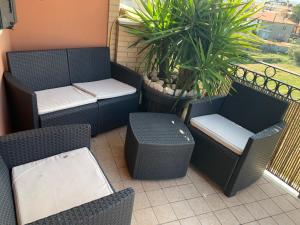 un patio con sedie, tavoli e piante di vimini di Andrew Home a Villa Rosa