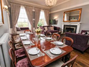 een eetkamer met een tafel en een woonkamer bij The Stables and West Wing in York